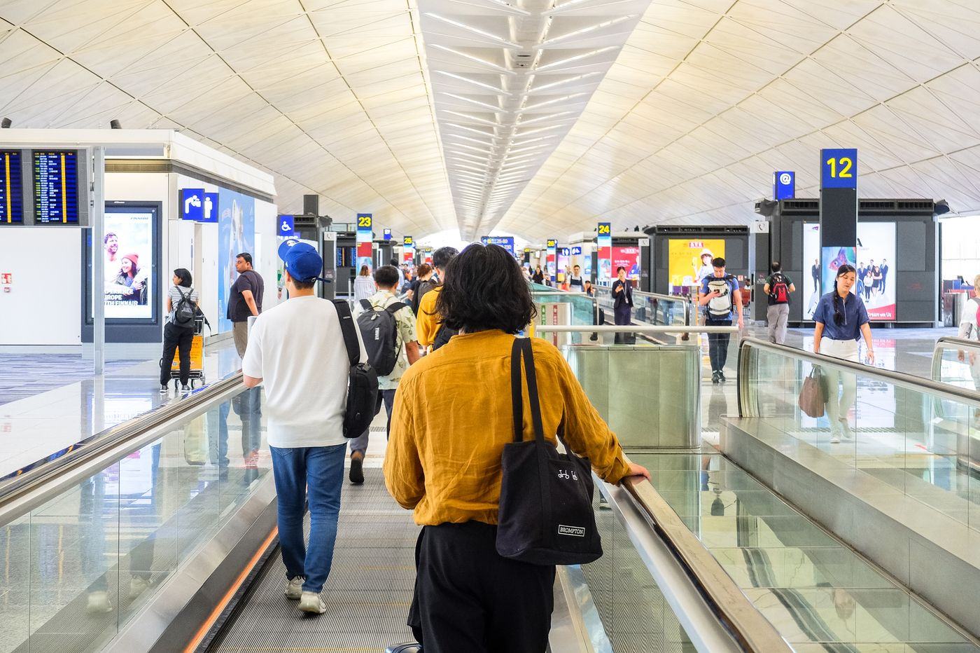 Travellers moving through a busy airport terminal
